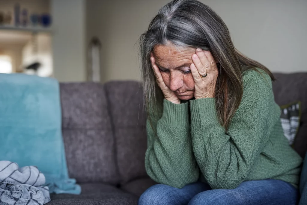 Sad woman with head in hands