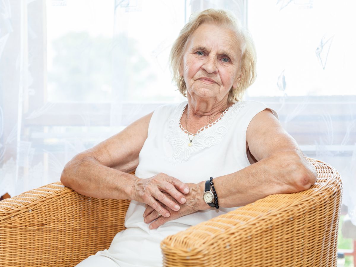 Carer story image with elderly woman sitting in wicker chair