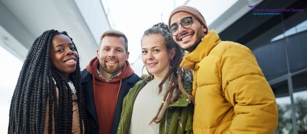 A picture of 4 adults standing together wearing winter clothing.