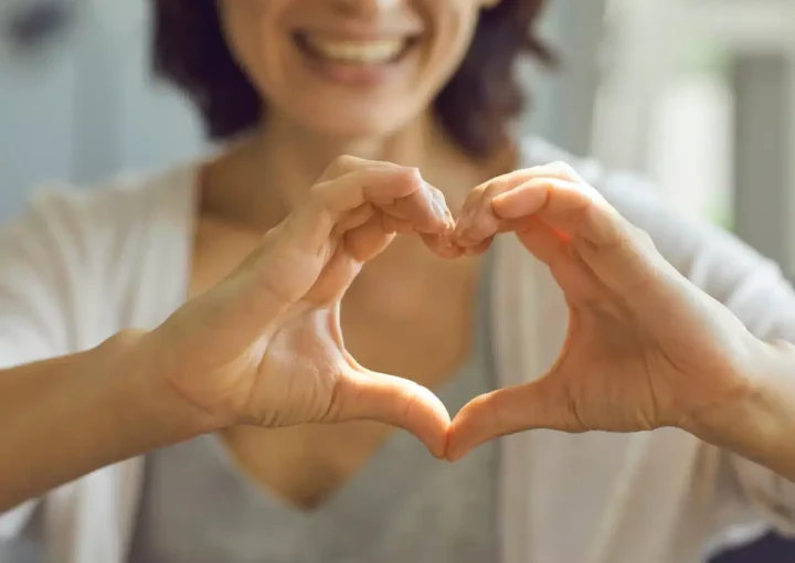 woman holding hands in heart shape