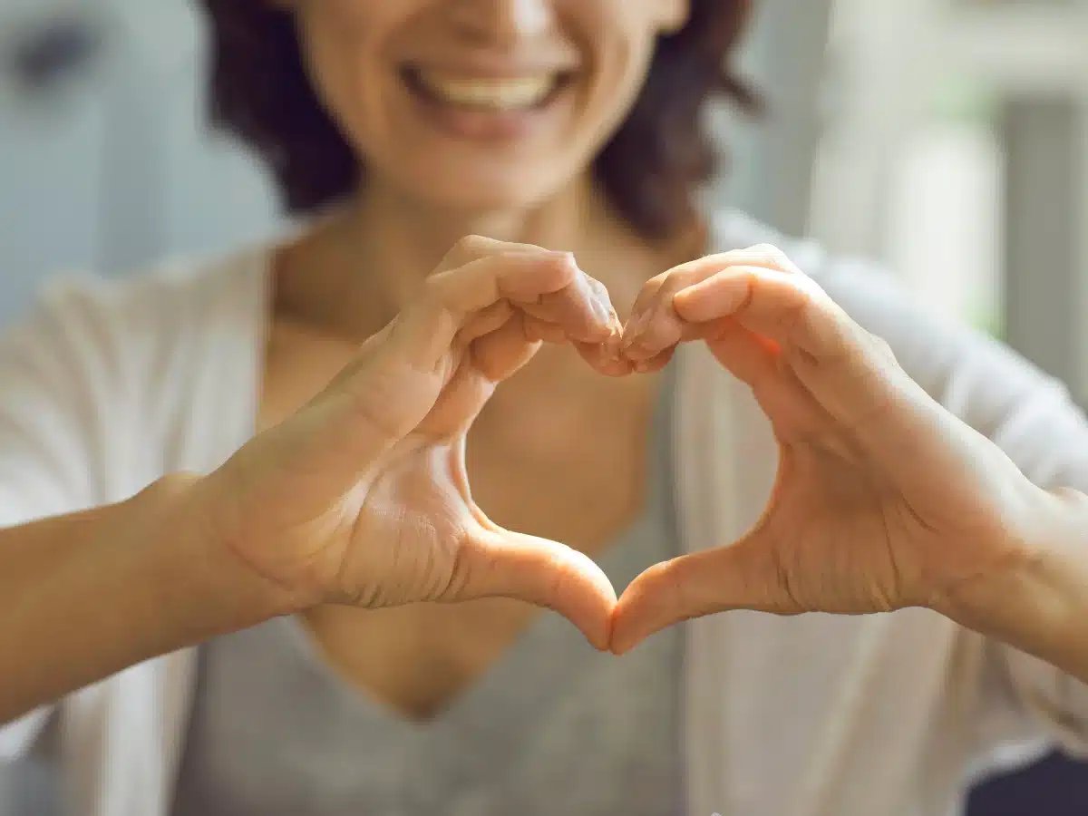 woman holding hands in heart shape