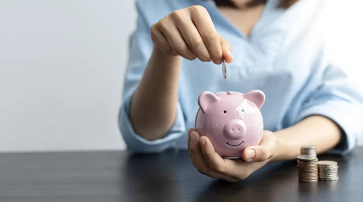 Person putting money in piggy bank