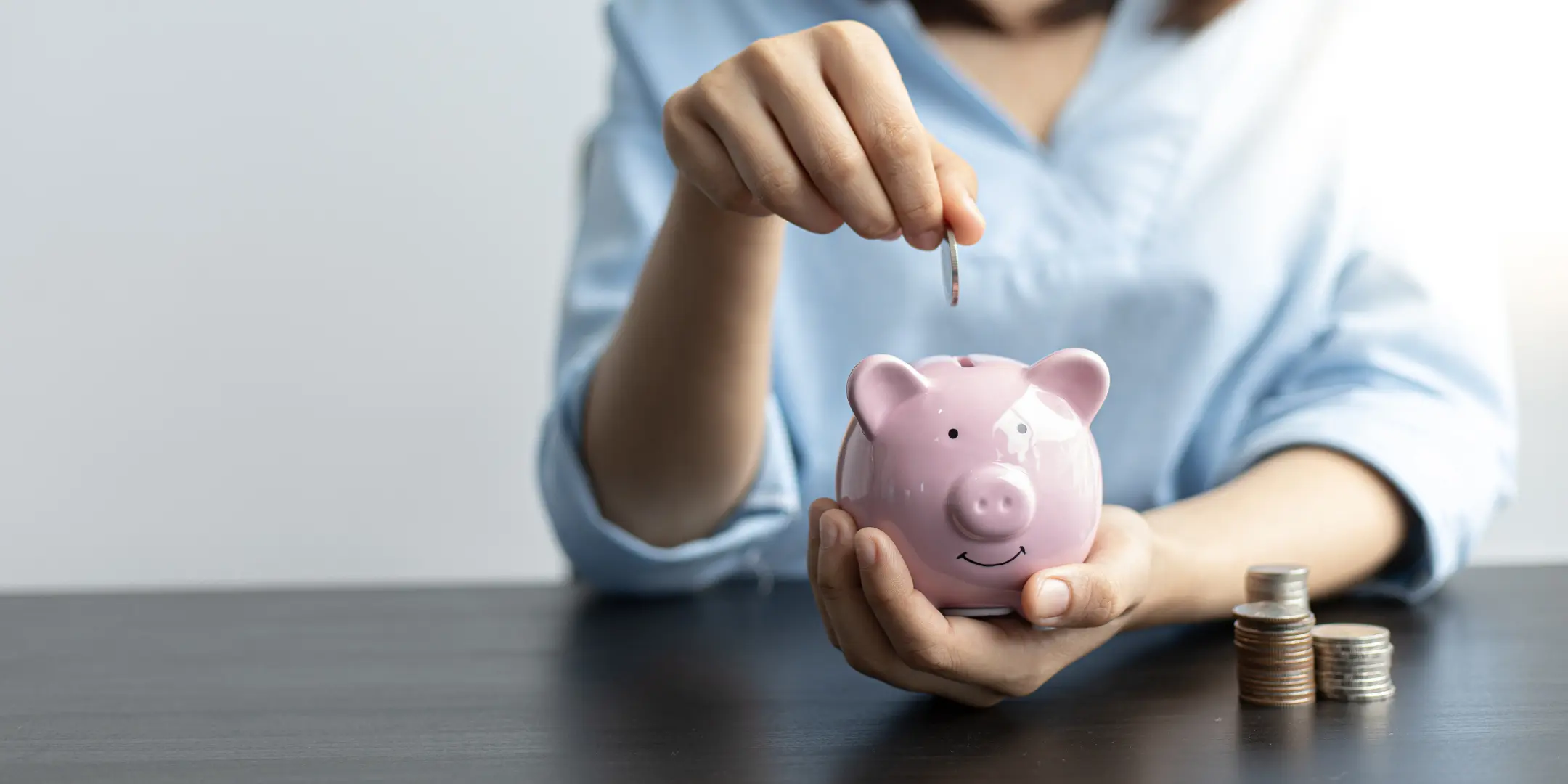 Person putting money in piggy bank