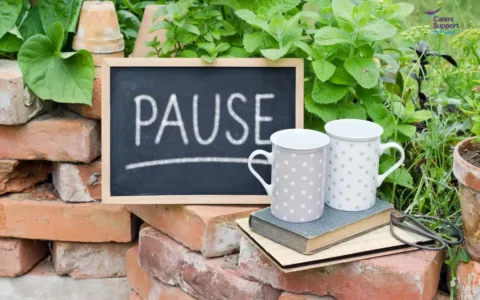Two mugs in the garden with pause sign