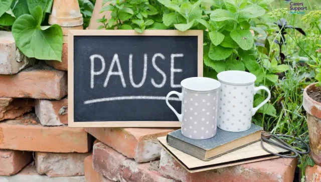 Two mugs in the garden with pause sign