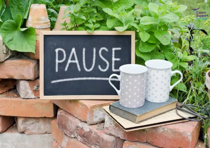 Two mugs in the garden with pause sign