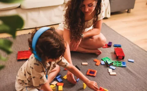 Young adult carer and child with puzzle