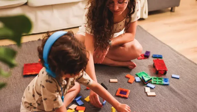 Young adult carer and child with puzzle