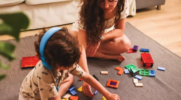 Young adult carer and child with puzzle