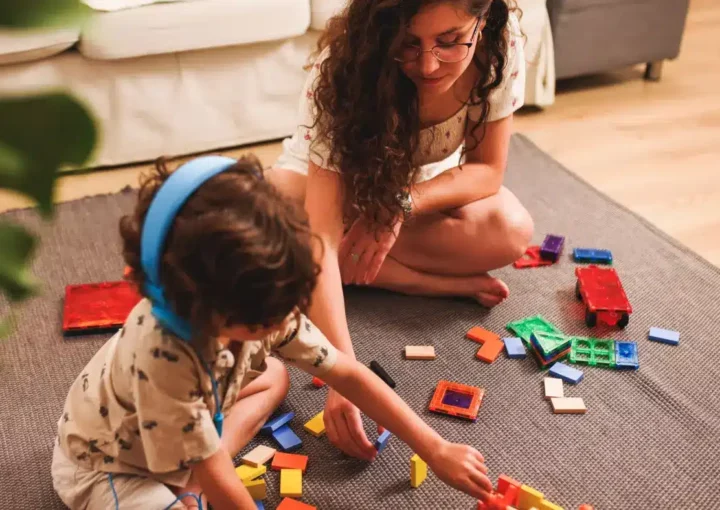 Young adult carer and child with puzzle