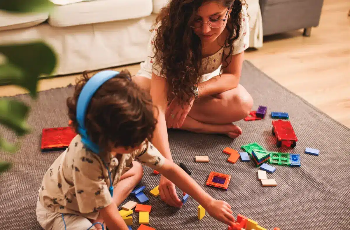 Young adult carer and child with puzzle